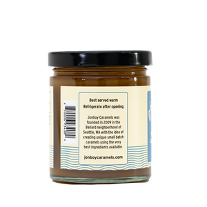 Side of view of caramel sauce jar with description of Jonboy Boy Caramel company info. "Best served warm. Refrigerate after opening."